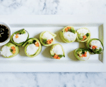 plate with veggie sushi made of cucumber, rice, avocado, and green onion
