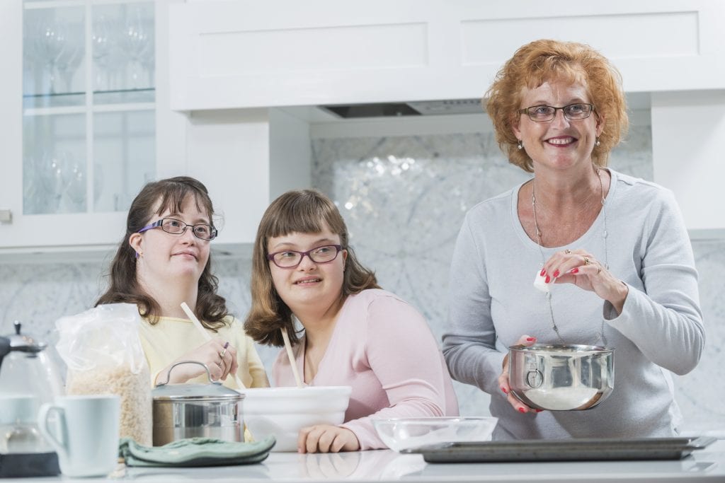 Mother and two daughters with down syndrome, baking