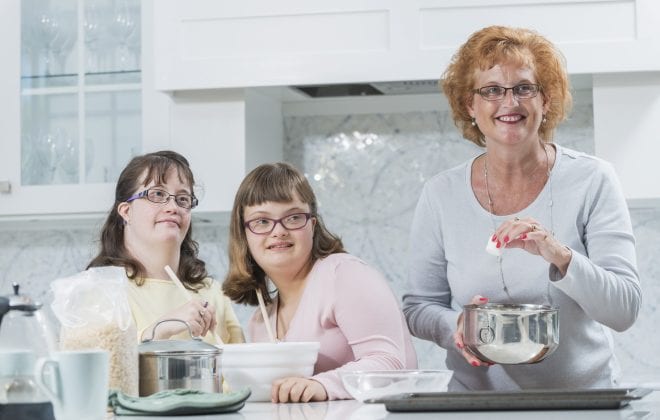 Mother and two daughters with down syndrome, baking