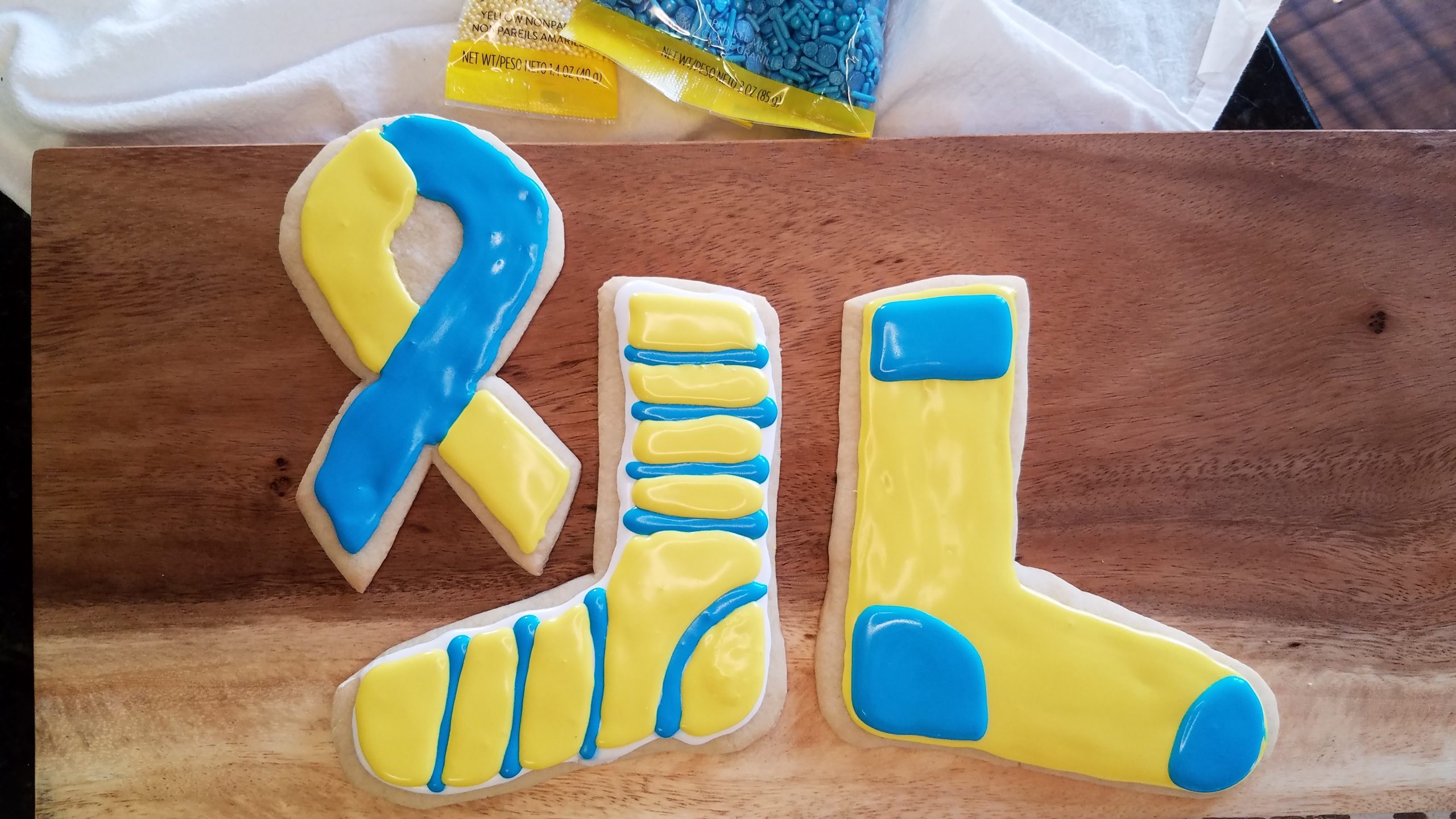 yellow and blue sugar cookies: sock and awareness ribbon