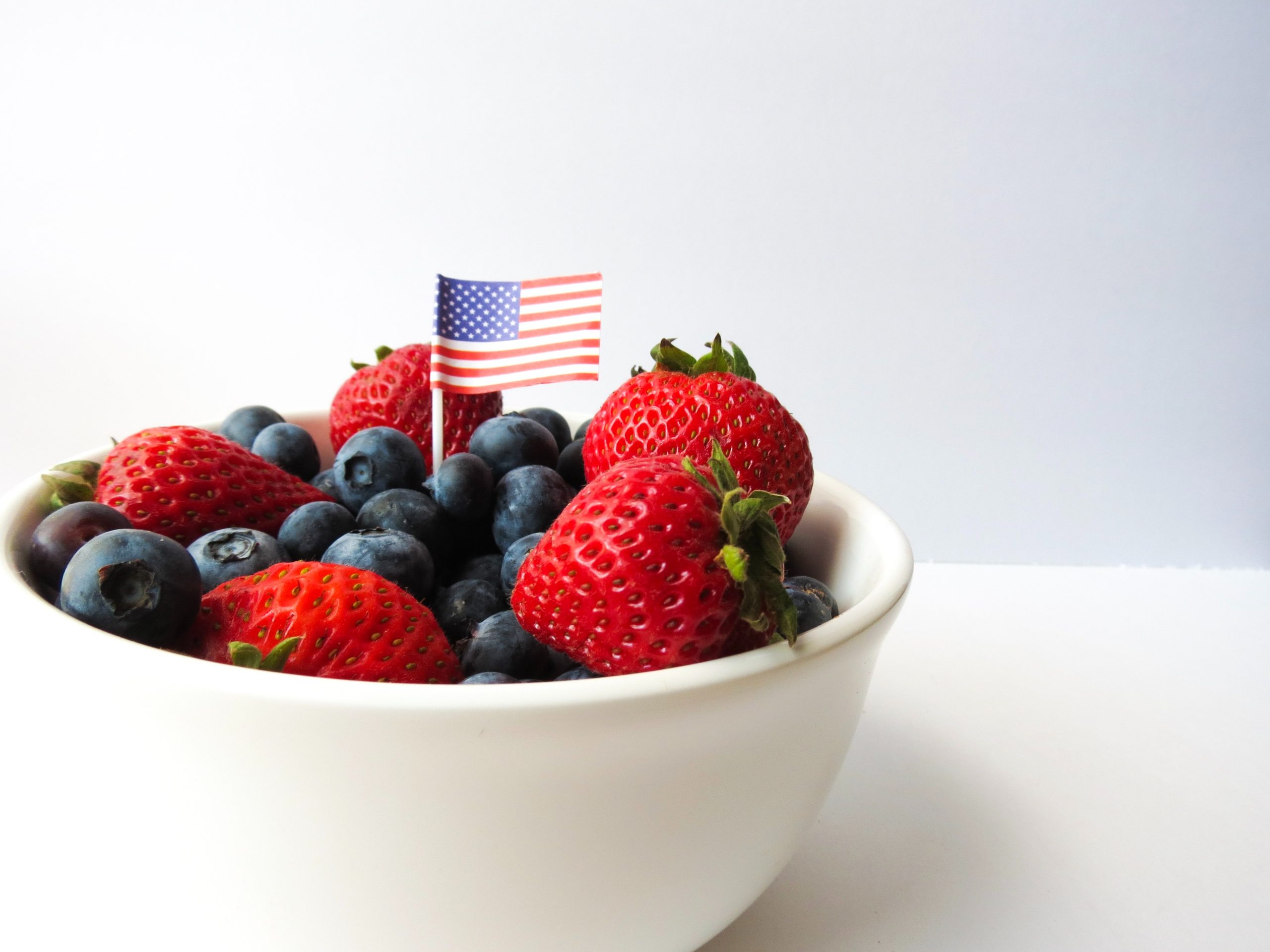 American flag toothpick in a bowl of strawberries and blueberries